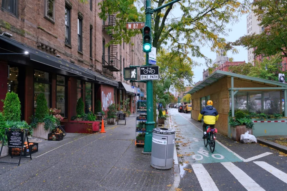 Green painted bike lane in New York City between sidewalk and outdoor dining kiosks